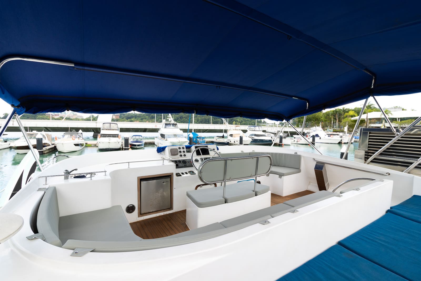 The flybridge under its bimini, with the upper helm, sink and drinks fridge