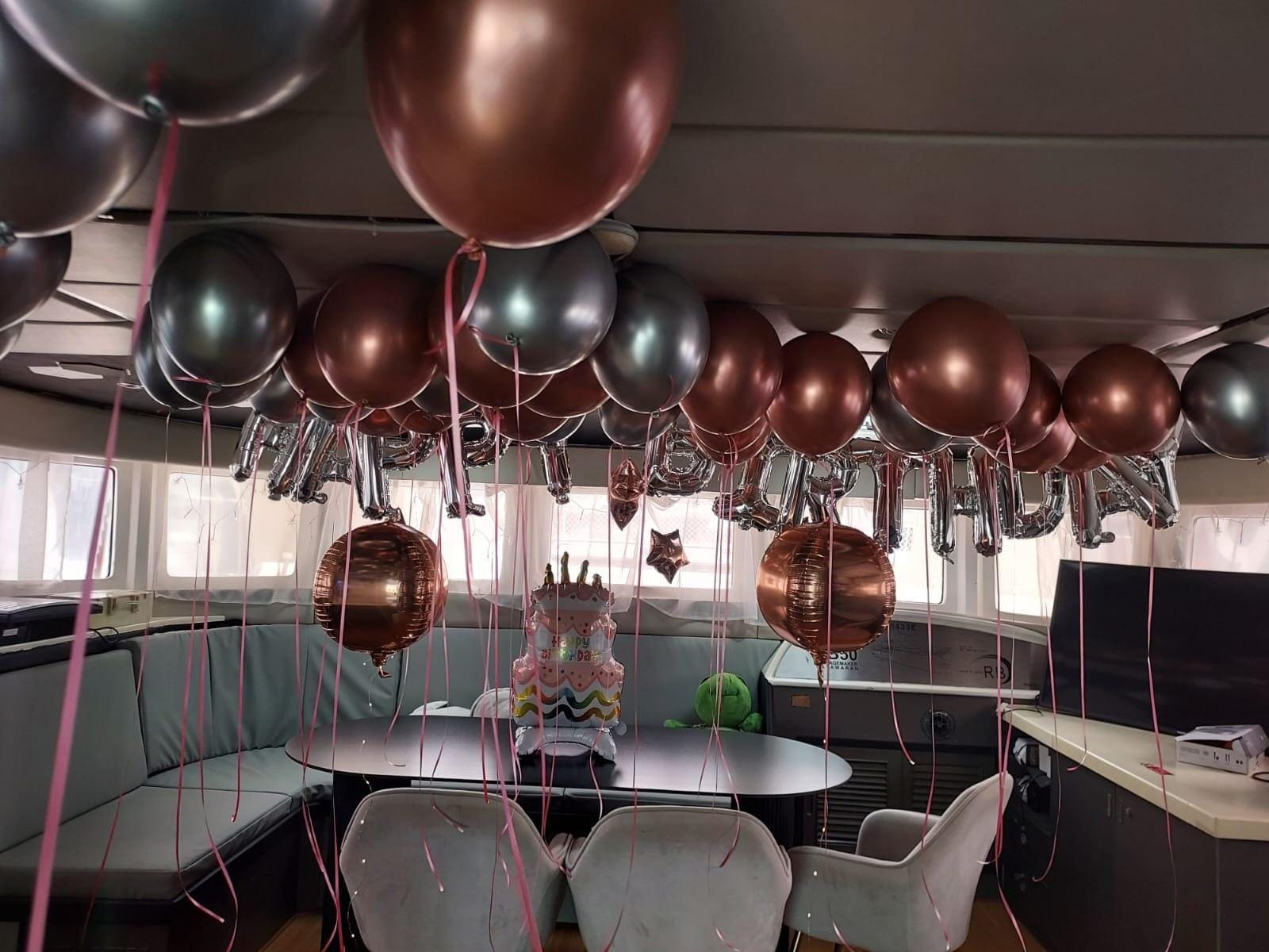 The air-conditioned saloon dressed for a birthday, dining table and television behind