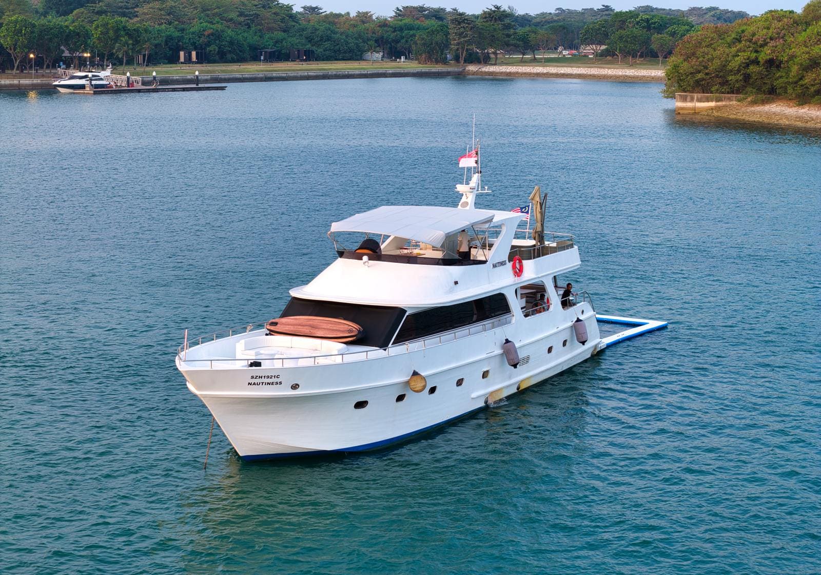 Bow-on view at anchor near Lazarus Island, floating pool set up along the starboard rail