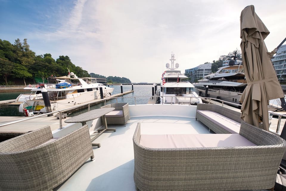 Open upper aft deck with rattan sofas and an umbrella, berthed at Superyachts' Corner