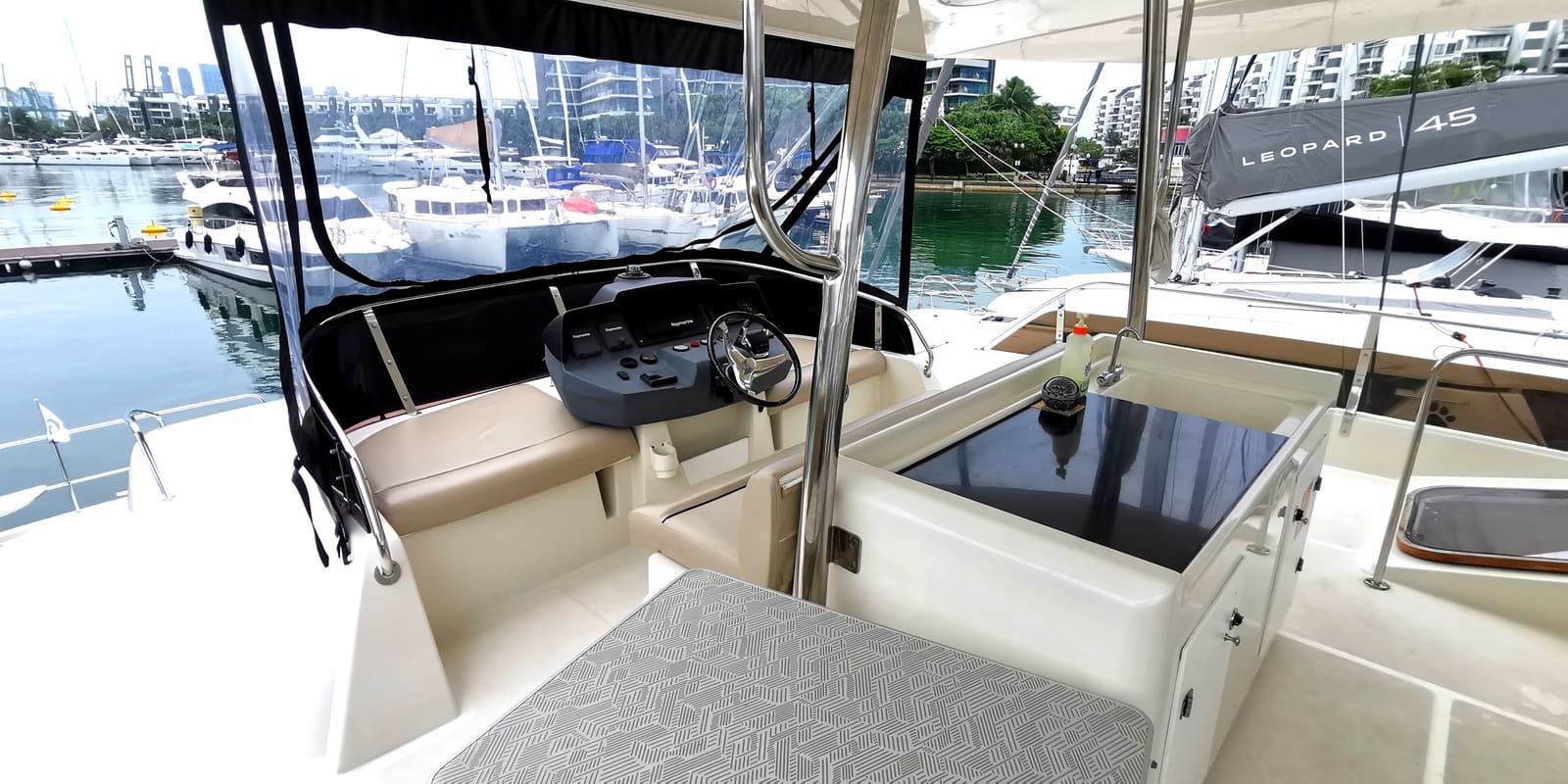 Upper helm on the flybridge, looking across the marina to the Singapore skyline
