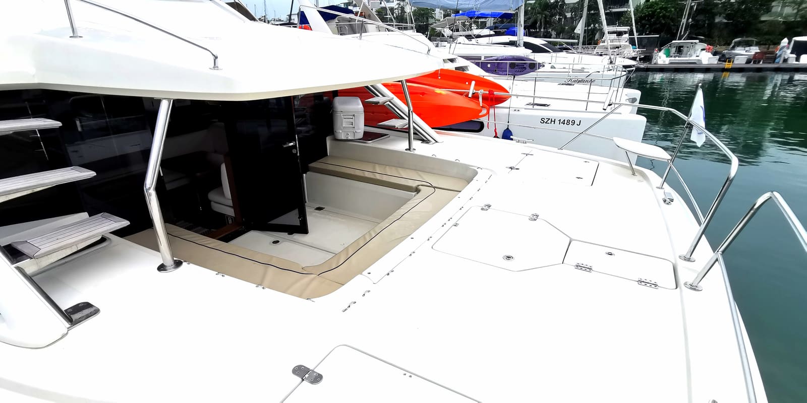 Wide foredeck spanning both hulls, with the sunken sun pad and the steps up to the flybridge